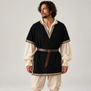 Man wearing a black and cream medieval Celtic costume with a brown waist belt