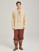 Man wearing a beige medieval tunic with rust brown trousers